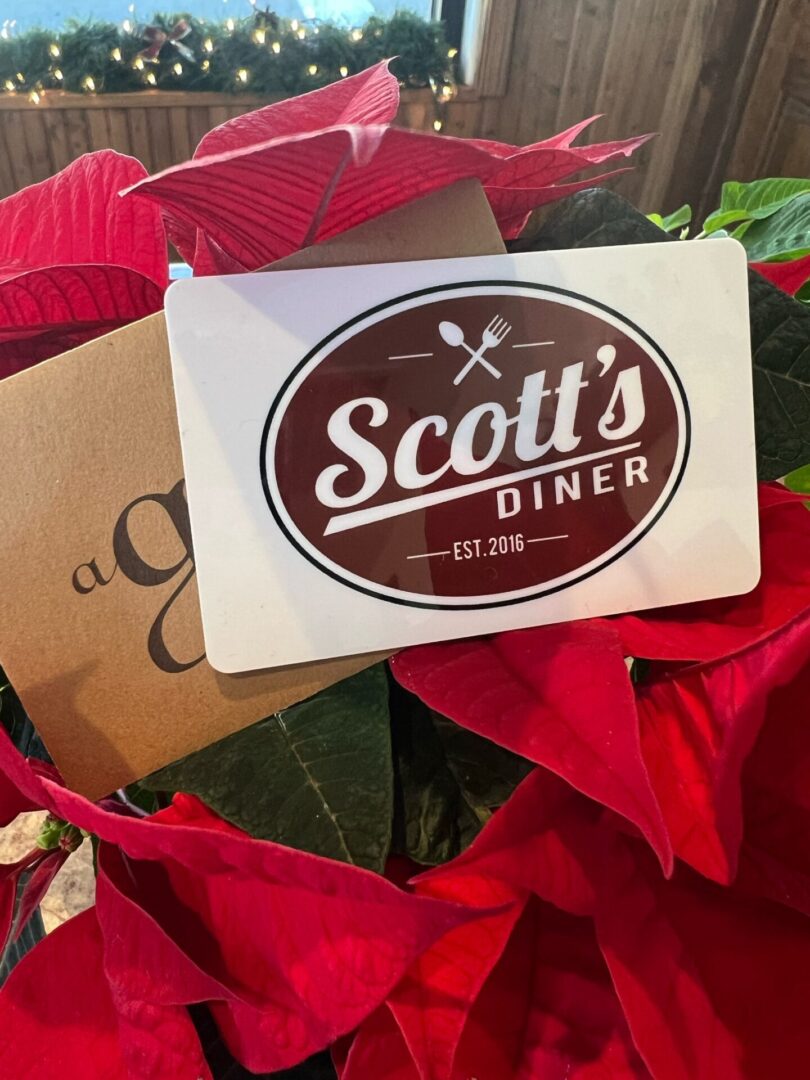 Scott's Diner gift card on red flowers.