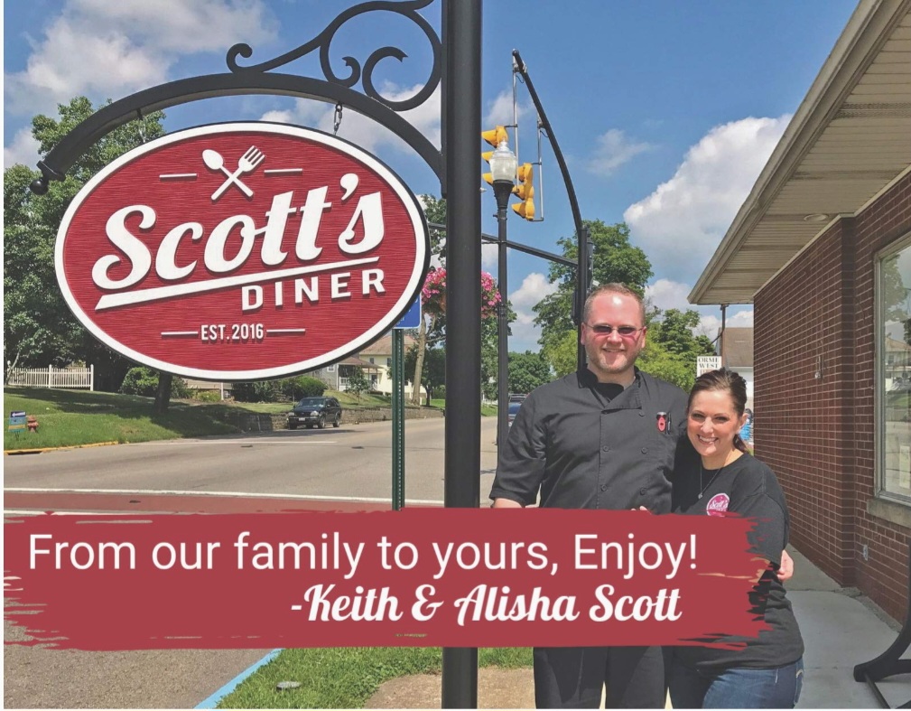 Scott's Diner sign with owners outside.