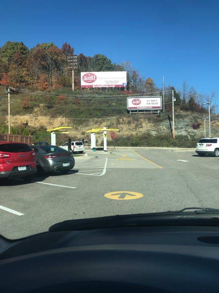 Cars parked in a lot with Scott's sign.